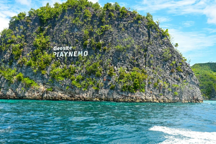 An island with a sign on it in the middle of the ocean